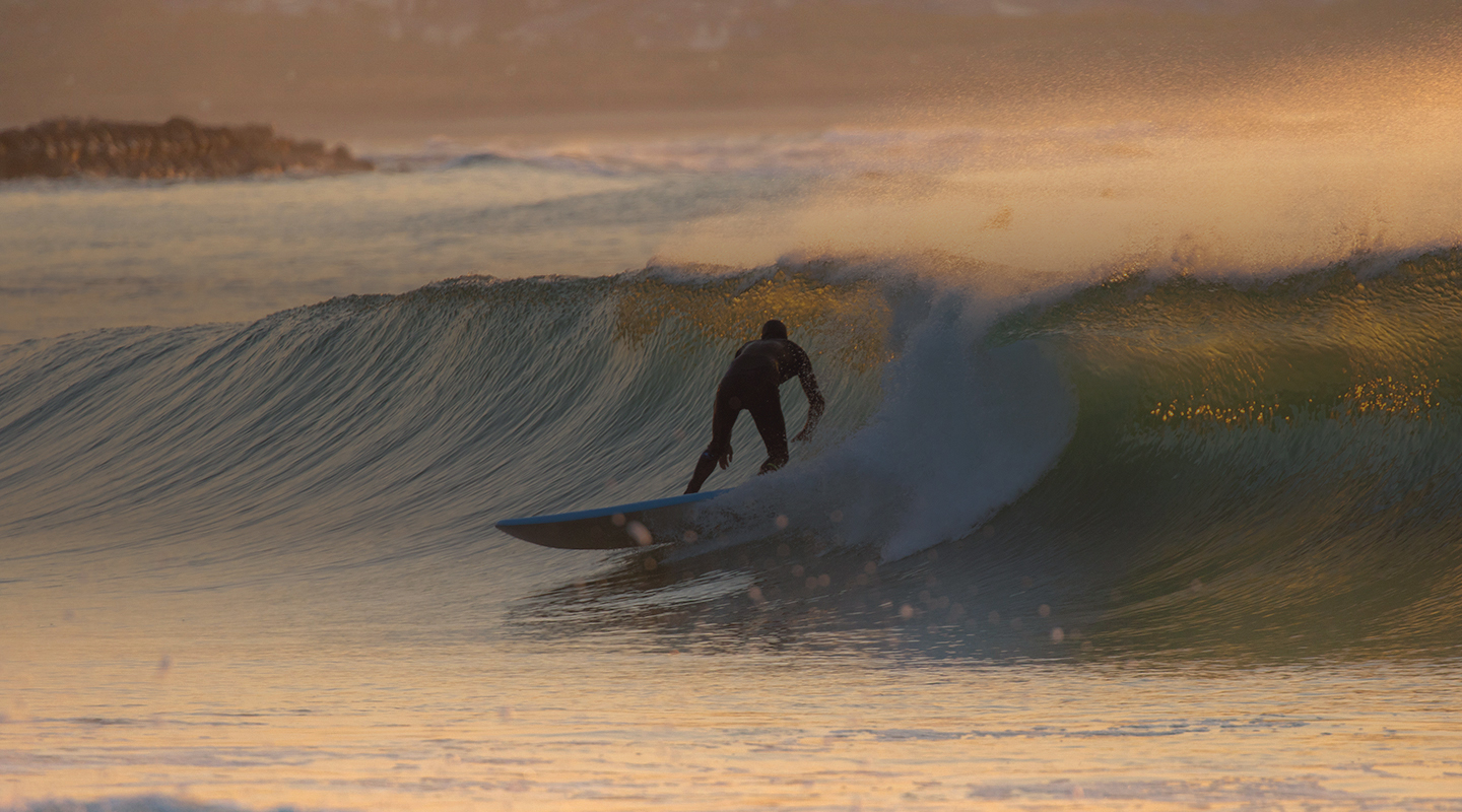 Surfer on a wave during sunset