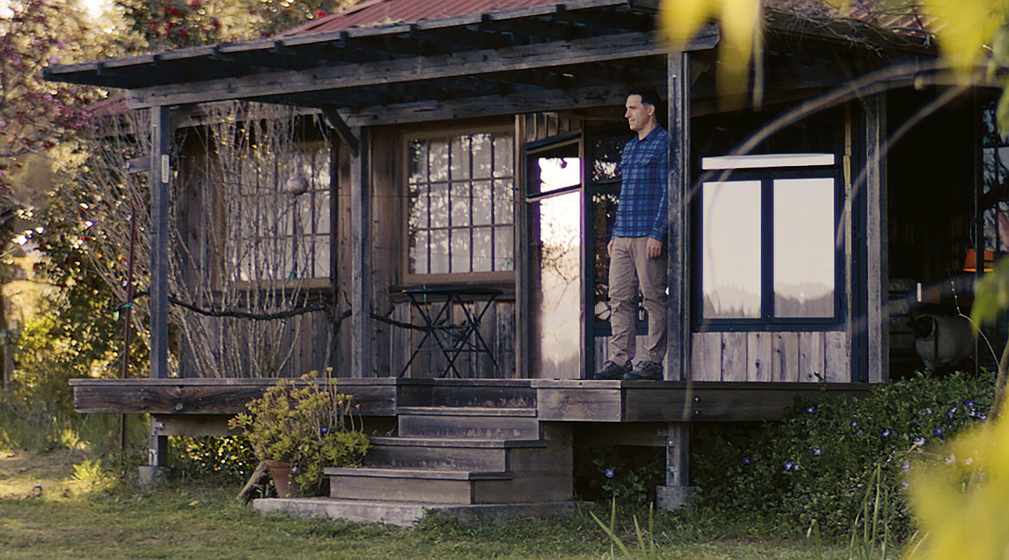 Derek Rohlffs Winemaker on porch of cabin in the forest